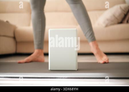 Femme d'âge moyen faisant des exercices à domicile. Mode de vie actif et équipement de fitness pour la pratique du bien-être. Banque D'Images