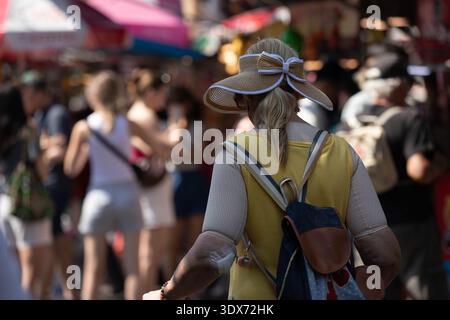 BANGKOK, THAÏLANDE-1er février 2026 : sac à dos touristique senior femme marchant dans le marché, voyageur explorant le marché en plein air, vue arrière, marché de Chatuchak. Banque D'Images