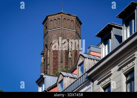 Plan détaillé de la tour en briques historiciste de la fabrique Stephan à Cologne, en Allemagne, s'élevant au-dessus des dortoirs résidentiels sous un ciel bleu clair Banque D'Images