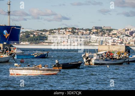 Trafaria Lisbonne Portugal 24 décembre 2025. Les bateaux de pêche restent ancrés tandis que les oiseaux de mer reposent sur une coque altérée le long du Tage. Banque D'Images