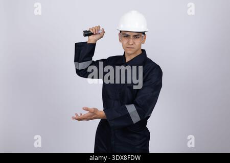 Ouvrier en uniforme bleu présentant avec la main Banque D'Images