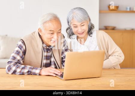 Couple using laptop at home Banque D'Images