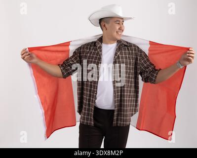 Homme en chapeau de cow-boy tenant le drapeau du Canada derrière son dos Banque D'Images