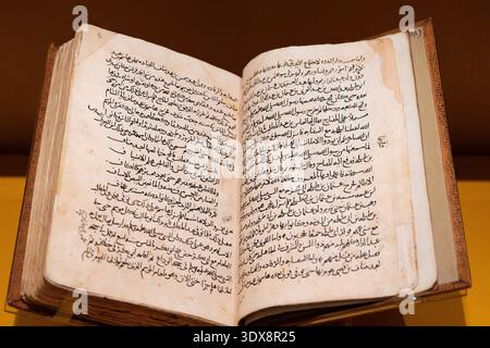 6 décembre 2025, Zayed National Museum Abu Dhabi, eau : ancien livre historique ouvert, montrant l'écriture arabe manuscrite et la calligraphie sur des pages âgées Banque D'Images