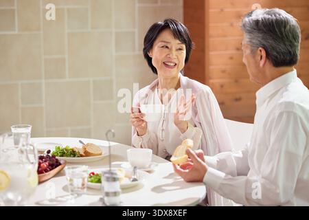Couple senior appréciant le petit déjeuner à la maison Banque D'Images