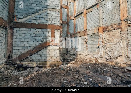 Structure de bâtiment abandonnée avec des murs de briques intérieurs en ruine et des poutres en bois apparentes Banque D'Images