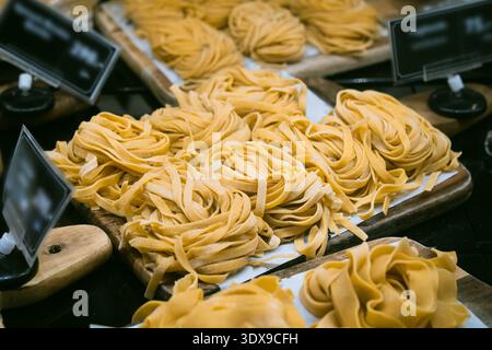 Pâtes maison italiennes faites à la main. Pâtes italiennes fraîches, roulées en nids caractéristiques. À en juger par la largeur des rubans plats, c'est tagliatelle Banque D'Images