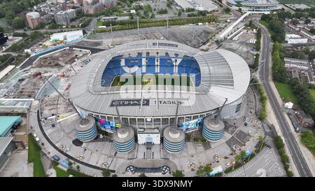 La vue aérienne de l'emblématique stade Etihad, qui abrite Manchester City, se distingue par son architecture distinctive dans le paysage urbain de Mancheste Banque D'Images