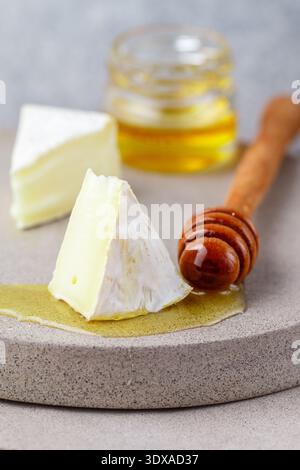 Délicieux fromage à pâte molle au camembert de moule blanc ou brie au miel. Hors-d'œuvre gastronomique avec vin. Mise au point sélective, faible profondeur de champ, espace de copie Banque D'Images