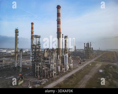 Vue aérienne des tours industrielles perçant la ligne d'horizon, contrastant avec les tons discrets du paysage environnant, créant un p industriel dur Banque D'Images