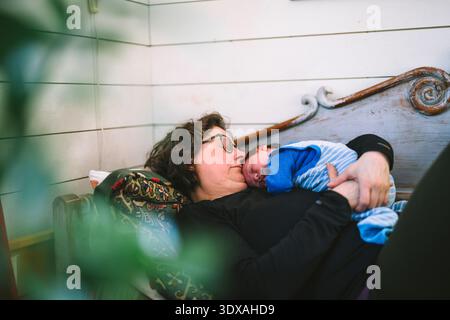 Grand-mère dormant avec petit-fils sur le canapé à la maison Banque D'Images