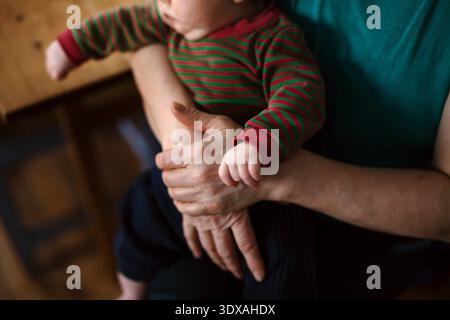 Vue en grand angle de la section médiane de la grand-mère assise avec son petit-fils à la maison Banque D'Images