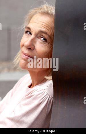Portrait d'une femme âgée appuyée sur le mur Banque D'Images