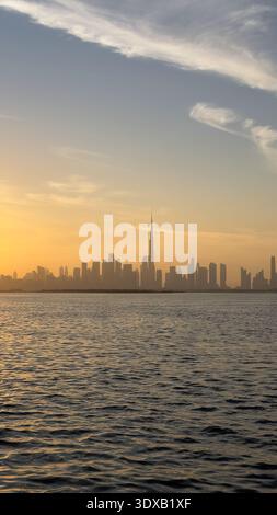 Vue sur les gratte-ciel de la ville depuis le port de Dubai Creek sur un coucher de soleil doré Banque D'Images