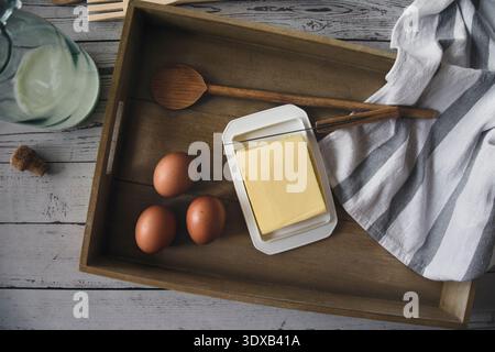 Beurre et oeufs, ustensiles de cuisine et lait dans une bouteille, cuisine rustique maison préparation des aliments vue de dessus Banque D'Images