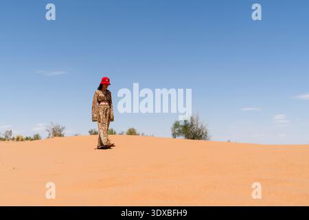 Ouzbékistan - 30 mai 2025 : jeune femme marchant sur les dunes de sable dans le désert de Kyzylkum Banque D'Images