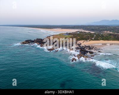 Vue aérienne de l'endroit où le promontoire rocheux rencontre l'océan turquoise, contrastant avec la plage de sable et la végétation dense, Sawtell, Nouvelle-Galles du Sud, A Banque D'Images