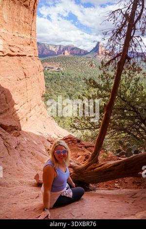 Birthing Cave à Sedona, Arizona. Femme blonde randonneur assis dans la grotte, posant Banque D'Images
