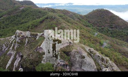 Vue aérienne d'une grande formation rocheuse entourée de forêt dans un paysage montagneux naturel. Banque D'Images