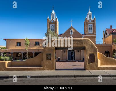 Winslow, États-Unis - 08 mai 2023 : vue de l'église historique la Purisima Concepcion, encadrée par une arche rustique en adobe, sous un ciel bleu clair. Banque D'Images