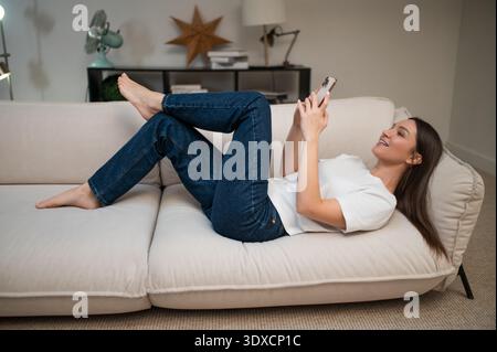 Joyeuse jolie jeune femme faisant selfie et se sentant flirty Banque D'Images