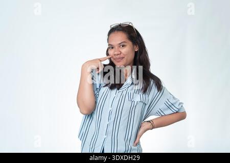 Portrait amical d'une jeune femme indonésienne portant des lunettes. Photographie en studio professionnelle pour l'enseignement, les entreprises et les concepts modernes d'environnement de travail. Banque D'Images