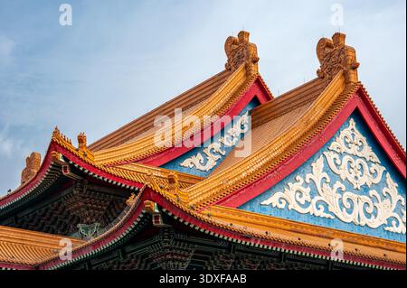 Gros plan détaillé d'un toit de temple orange traditionnel à Taipei, Taïwan, mettant en évidence des tuiles ornées, des avant-toiTS décoratifs et un savoir-faire complexe Banque D'Images