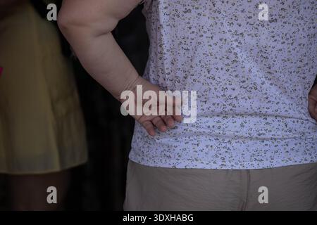 Femme senior debout avec la main sur la hanche tout en faisant du shopping sur le marché, voyageur explorant le marché extérieur, texture de la peau, gros plan, marché Chatuchak. Banque D'Images