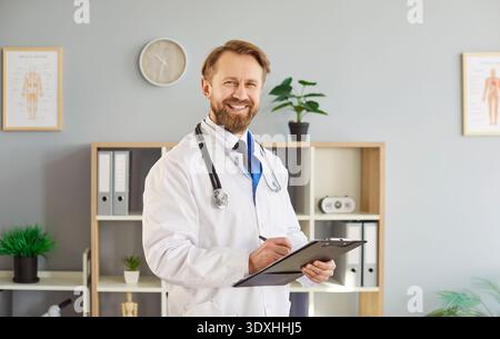 Portrait d'un thérapeute masculin souriant en uniforme posant dans un cabinet de clinique Banque D'Images