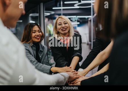 Divers professionnels se joignent à eux dans un moment de travail d'équipe dans un bureau moderne pour une ambiance d'entreprise collaborative Banque D'Images