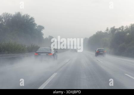 Vue arrière arrière de nombreuses voitures conduisant rapidement sur route humide après la pluie en Europe. Accident de la route : effondrement des véhicules aux heures de pointe. Transport Banque D'Images