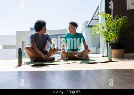 Pendentif en forme de larme en bois reposant sur une surface blanche, suspendu à un mince cordon sombre sous l'éclairage du studio Banque D'Images
