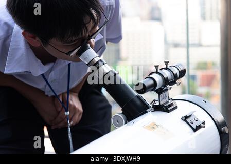 Un homme observe le ciel avec un télescope avant que l'éclipse lunaire totale n'apparaisse lors d'un événement astronomique à Bangkok. Une éclipse lunaire totale est vue à travers la Thaïlande, y compris Bangkok, la lune de sang apparaît dans le ciel au-dessus de Bangkok pendant 6,23 heures. Banque D'Images