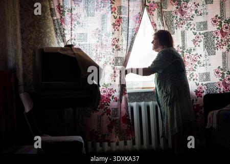 18 août 2022, Bakhmut, oblast de Donetsk, Ukraine : VALENTINA PAVILIVNA BONDARENKO, 79 ans, regarde par la fenêtre de sa chambre principale depuis sa maison à la périphérie est de Bakhmut. Les bombardements ont été régulièrement entendus alors que les forces ukrainiennes retenaient une tentative d'avance sur la région par les troupes russes alors que la Russie bombarde la ville quotidiennement. (Crédit image : © Daniel Carde/ZUMA Press Wire) USAGE ÉDITORIAL SEULEMENT ! Non destiné à UN USAGE commercial ! Banque D'Images