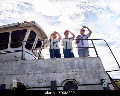 Trois femmes profitant d'une journée ensoleillée sur un bateau pendant leur aventure de voyage Banque D'Images