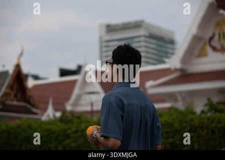 BANGKOK, THAÏLANDE-4 février 2026 : homme aux cheveux courts priant devant la statue de bouddha, communication non verbale, vue arrière, à Wat Rakang. Banque D'Images
