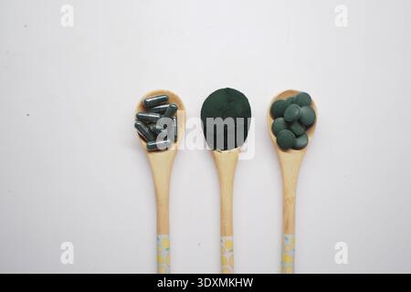 Différentes formes de spiruline en cuillères en bois pour la santé Banque D'Images