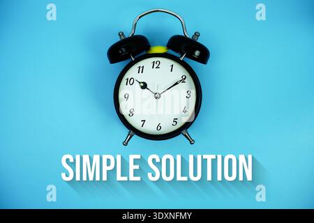Texte de solution simple et réveil sur fond bleu Banque D'Images