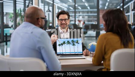 Agent de voyage aidant Une famille souriante à planifier leurs vacances de croisière. Une femme d'affaires utilisant Un ordinateur portable pour réserver des voyages de vacances Banque D'Images