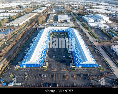 Vue aérienne d'un bâtiment distinctif en forme de U avec un toit à motifs bleus et blancs au milieu d'une mer de stationnement et des bâtiments environnants, Kent, Washingto Banque D'Images