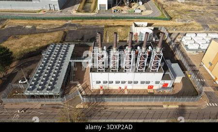 Vue aérienne du complexe industriel avec des contrastes frappants entre l'argent métallique des unités de refroidissement et les lignes verticales sombres de l'échappement Banque D'Images