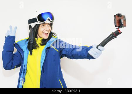 Gros plan jeune souriant femme skieuse satisfaite porter chaud rembourré coupe-vent veste chapeau ski masques regarder caméra voyage repos passer week-end hiver mer Banque D'Images