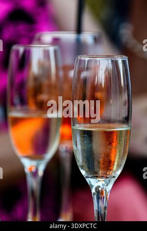Deux flûtes en cristal partiellement remplies de vin blanc assis sur un bar lors d'un banquet de mariage. Banque D'Images