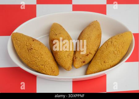 Quatre hors-d'œuvre au Kibbeh doré frits servis dans une assiette blanche Banque D'Images