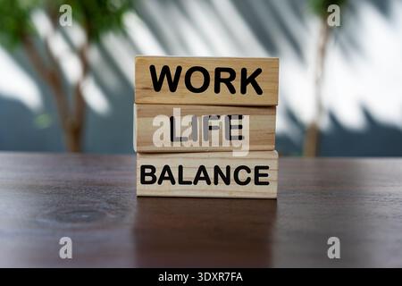 Blocs de bois empilés orthographiant « WORK LIFE BALANCE » sur une surface en bois avec un arrière-plan doux et flou. Banque D'Images