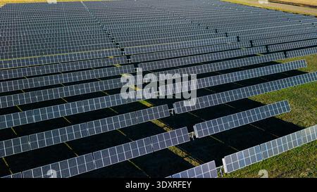 Drone aérien vue rapprochée de la centrale solaire avec de longues rangées de panneaux photovoltaïques générant de l'énergie renouvelable Banque D'Images