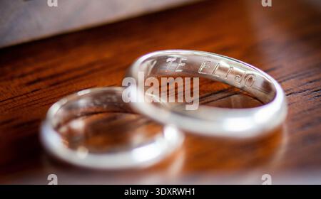 Gros plan de deux bagues de mariage en argent gravées avec le frase 'te elijo' (espagnol pour i Choose You). reposant sur une surface en bois. Symbole de l'amour. Banque D'Images