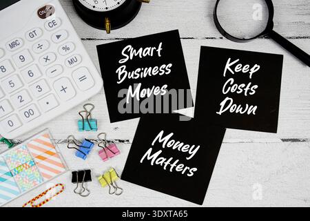 Smart Business bouge, garder les coûts bas, l'argent compte texte écrit sur papier note avec calculatrice et loupe sur fond en bois Banque D'Images