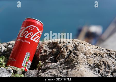 Rouge Coca-Cola original peut être perché sur la roche côtière accidentée avec turquoise mer Méditerranée et horizon flou en arrière-plan.Nice, France Banque D'Images