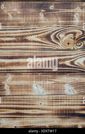 Vue de dessus rapprochée de planches en bois carbonisé avec un beau grain et des nœuds très contrastés. Surface en bois brun rustique idéale pour le design organique Banque D'Images